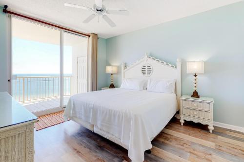 a bedroom with a white bed and a balcony at The Beach Club 1101C in Gulf Highlands