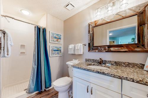 a bathroom with a toilet and a sink and a mirror at The Beach Club 1101C in Gulf Highlands