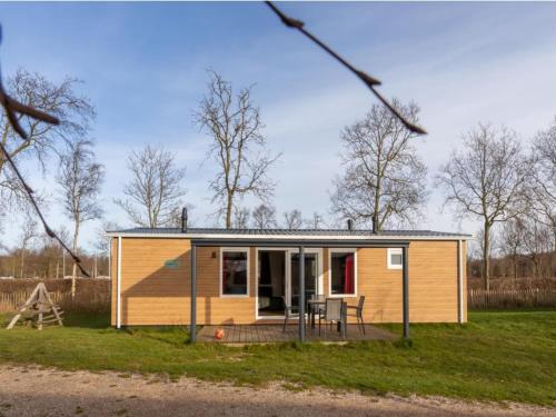 a tiny house with a porch and a playground at Villa in Burgh-Haamstede with Garden in Burgh Haamstede