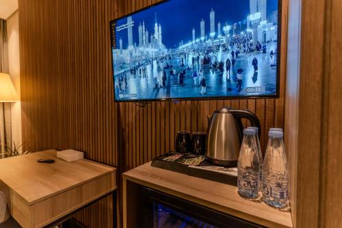 a room with a tv and a table with bottles at فندق هيل Hill Hotel in Al Madinah
