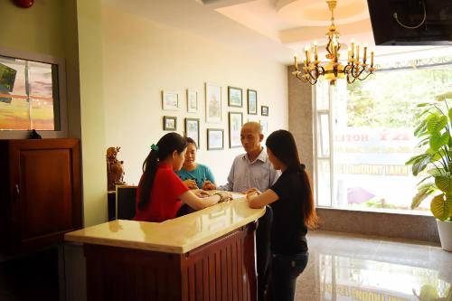 a group of people standing around a counter in a restaurant at Ly Ky Hotel in Quy Nhon