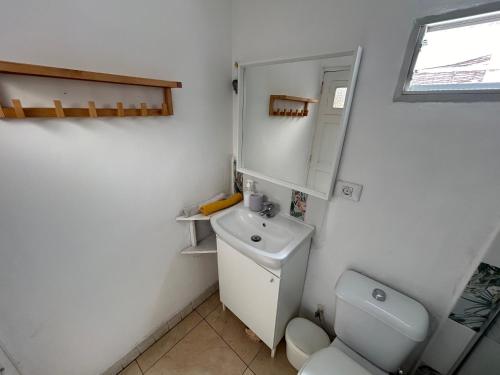 a white bathroom with a toilet and a sink at Ático Sol Vecindario in Vecindario