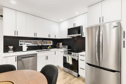 a kitchen with white cabinets and a stainless steel refrigerator at Modern Ballard Retreat Near Beach & Parks in Seattle
