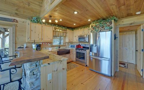 a kitchen with wooden cabinets and a stainless steel refrigerator at Majestic View in Mashburn Mill