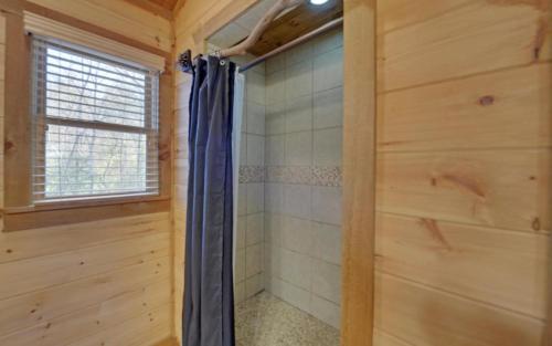 a bathroom with a shower in a wooden cabin at Majestic View in Mashburn Mill