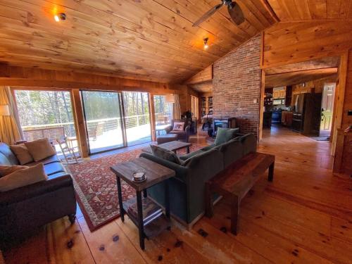 a living room with a couch and a table at Amazing lakefront home in the White Mountains with game room theater 51PR in Whitefield