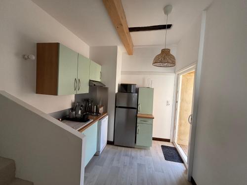 - une cuisine avec des placards verts et un réfrigérateur dans l'établissement Family, à Langres