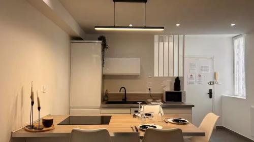 une cuisine avec une table et des chaises dans une pièce dans l'établissement L'élégant Central - Cosy, à Mâcon