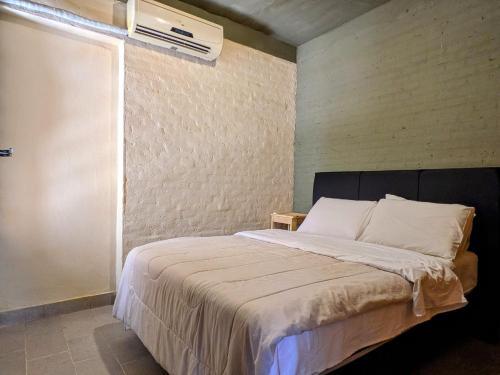 アスンシオンにあるAlojamiento Ecológico Asunciónのベッドルーム1室(ベッド1台、壁にエアコン付)