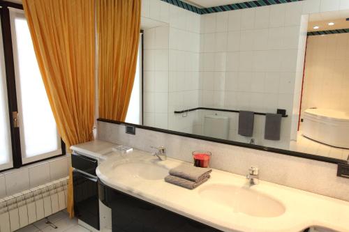 baño con lavabo y espejo grande en Il Castello B&B, en Varallo Pombia