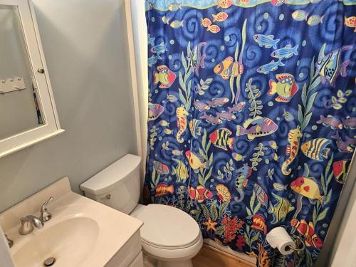 Un baño con inodoro y cortina de ducha. en Brant Beach - Lovely, 1St Floor Duplex, Only 3 Houses From The Beach No Smoking, And No Pets Permitted Property Now Has Electronic Locks - Tenant, en Brant Beach