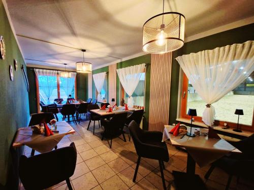 a dining room with tables and chairs in a restaurant at Reiterhof Schmidt, Gaststätte & Pension in Golk