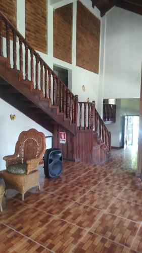 a living room with a chair and a staircase at The Blue Dolphin house in Tulián