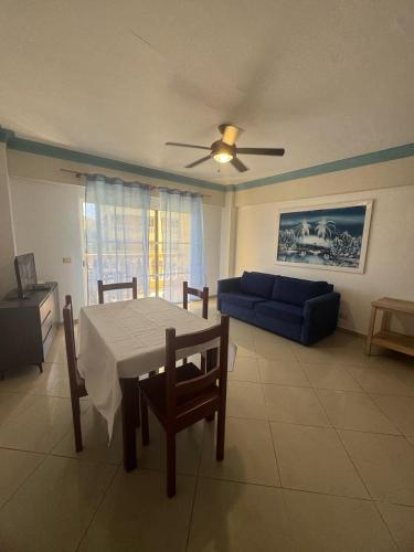 a living room with a table and a blue couch at Las Palmeras by Graziano in Boca Chica