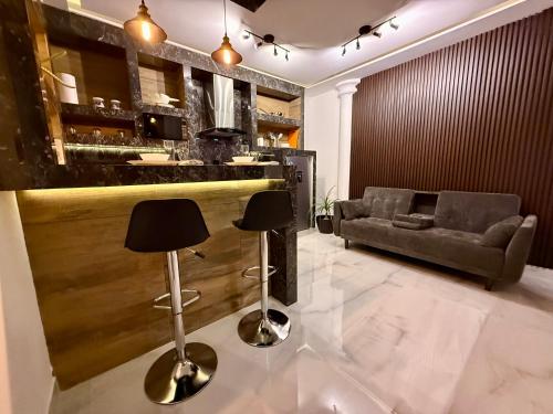 a lobby with a bar with two stools and a couch at Casa Solar Boutique Eco-Hotel Confort Suite in Minatitlán