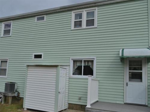 a green house with a door and a window at Beach Badges Wifi in Ship Bottom