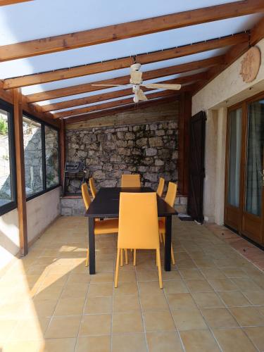 - une table à manger et des chaises sur la terrasse dans l'établissement Bas de Villa avec entrée indépendante en pleine nature, à Le Bar-sur-Loup