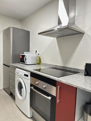 a kitchen with a stove top oven next to a microwave at Apartamentos Vernia 3-9 in Xàtiva