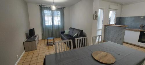 un salon avec un canapé et une chaise dans l'établissement Festiv'Mans72 - 2ch - Le Georges Durand - Circuit 24H, au Mans