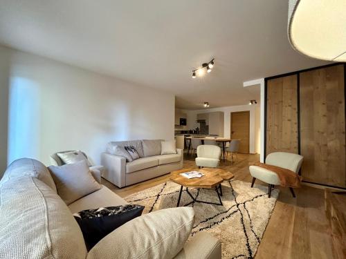 un salon avec un canapé et une table dans l'établissement Homency - Résidence L'Expression D02, à L'Alpe-d'Huez
