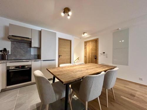 une cuisine avec une table et des chaises en bois dans l'établissement Homency - Résidence L'Expression D02, à L'Alpe-d'Huez