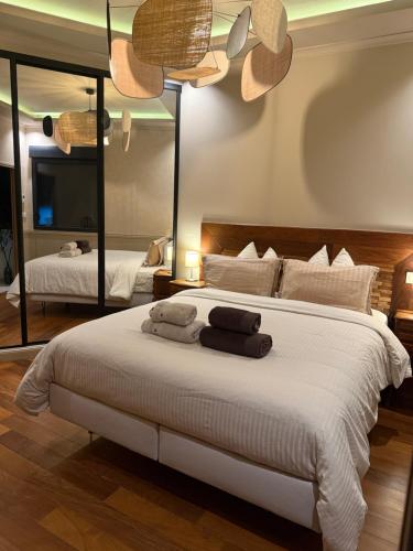 - une chambre avec un grand lit blanc et un grand miroir dans l'établissement L'Emperador, à Reims