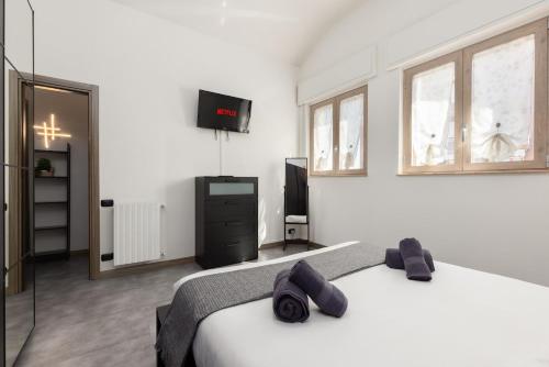 une chambre avec un lit et une télévision à écran plat dans l'établissement 8Min Airport Orio Al Serio - Attico Lusso e Terrazza, à Seriate