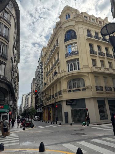 a tall building on a city street with a crosswalk at Hermoso Studio a metros del Obelisco in Buenos Aires