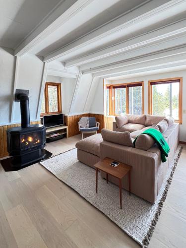 a living room with a couch and a wood stove at Lands End Private Lakeside Escape in Tobermory