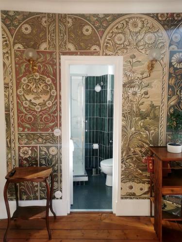 - une salle de bains avec toilettes dans une chambre avec papier peint dans l'établissement Chez Victor - proche mer - Veules-Les-Roses, à Veules-les-Roses