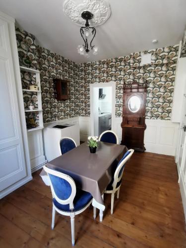 une salle à manger avec une table, des chaises et une horloge dans l'établissement Chez Victor - proche mer - Veules-Les-Roses, à Veules-les-Roses