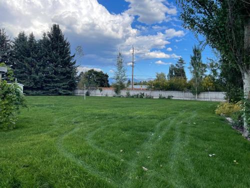 a yard with green grass and a fence at Country Way Inn in Kalispell