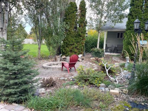 a garden with a red chair in a yard at Country Way Inn in Kalispell