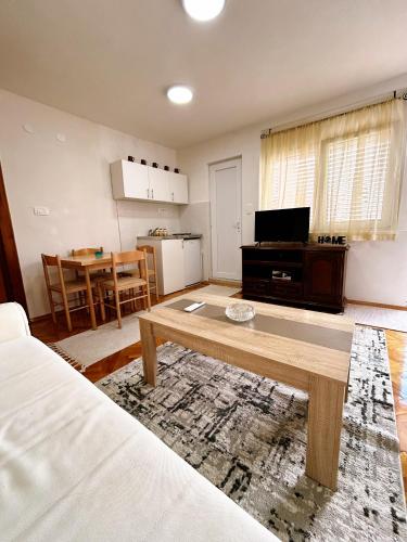 Una sala de estar con una mesa de café y una cocina. en Zinzula 3, en Šušanj