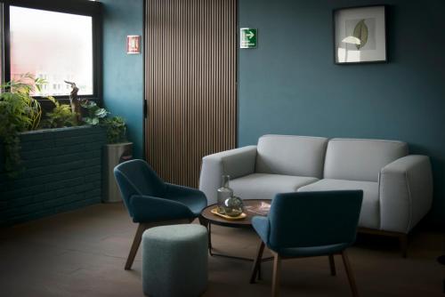 a living room with a couch and two chairs and a table at Hotel Flamencos Centro Histórico in Mexico City