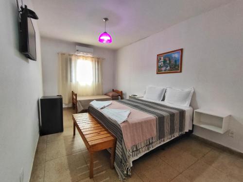 a bedroom with a bed and a tv in it at Hotel Pousada Caminho Pireneus in Pirenópolis