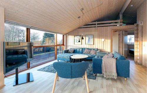 salon z niebieskimi meblami i dużym oknem w obiekcie Holiday Home Søstjerneparken Nordborg Vi w mieście Nordborg