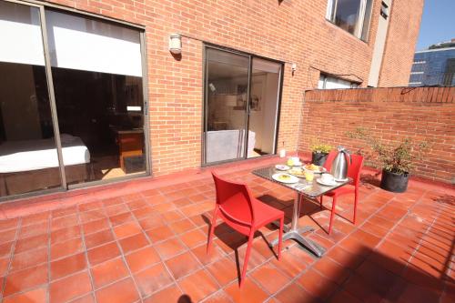 a patio with a table and chairs on a brick patio at Lancaster House in Bogotá