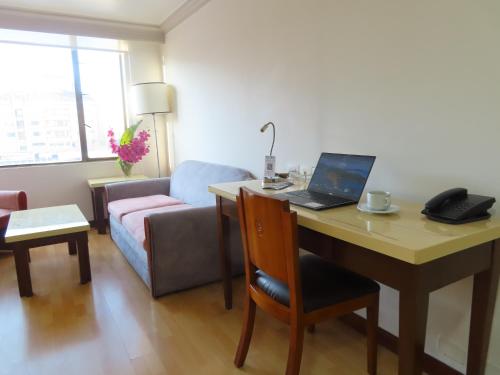 a living room with a desk with a laptop on it at Lancaster House in Bogotá