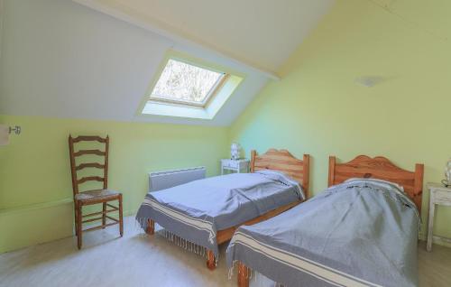 a attic bedroom with two beds and a window at Awesome Home In Hucqueliers With Wifi in Hucqueliers