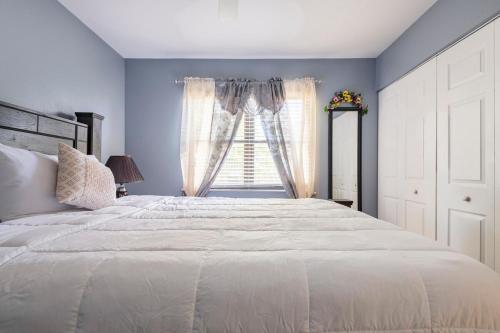 a bedroom with a large white bed and a window at paradise vacation luxury home in Palm Bay