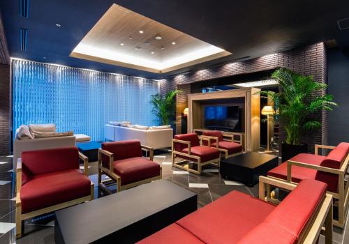 a waiting room with red chairs and a tv at Daiwa Roynet Hotel Kokura Ekimae in Kitakyushu