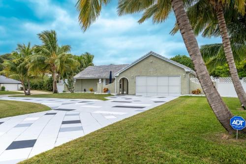 a house with palm trees in front of it at paradise vacation luxury home in Palm Bay