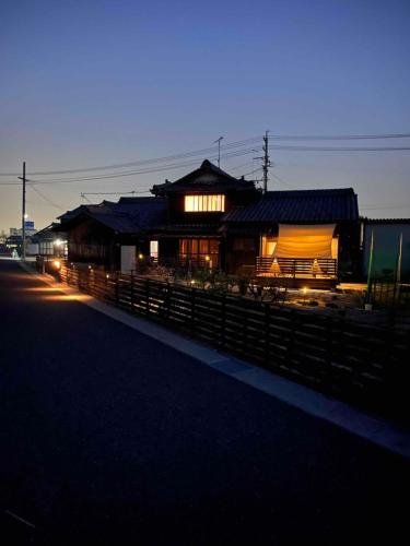 a building with a fence in front of it at 朝食夕食付きで最高ランクの飛騨牛希少部位と地元野菜の炭火焼きを堪能できる宿ゲストハウスつぐや in Kurono