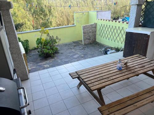 a wooden bench sitting on top of a patio at Tre e Trenta in San Teodoro