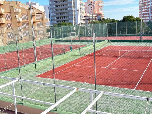 a tennis court with two tennis courts at Bahia Park Résidence in Cullera
