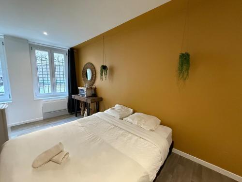 a bedroom with a white bed with a yellow wall at Suite Jaune #4#- Douceur & confort-self check-in in Roubaix