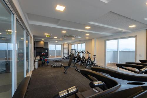 a gym with rows of treadmills in a building at Apart Moderno Proximo ao Mar in Vila Velha