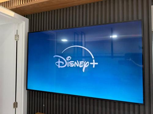 a large screen with a disney logo on a wall at Apart Moderno Proximo ao Mar in Vila Velha