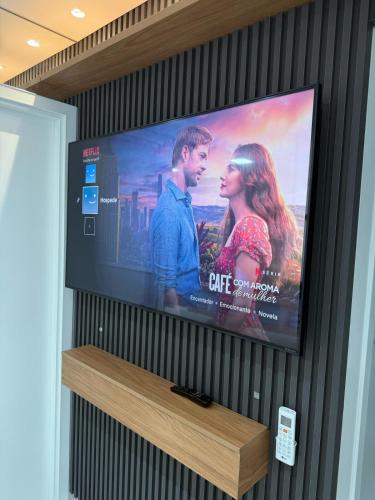 a flat screen tv hanging on a wall at Apart Moderno Proximo ao Mar in Vila Velha